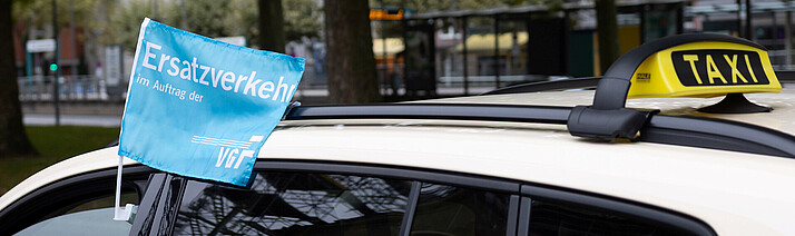 Ersatzverkehr mit Taxis Das Bild zeigt ein Taxi mit der Fahne als Hinweis auf den Ersatzverkehr.