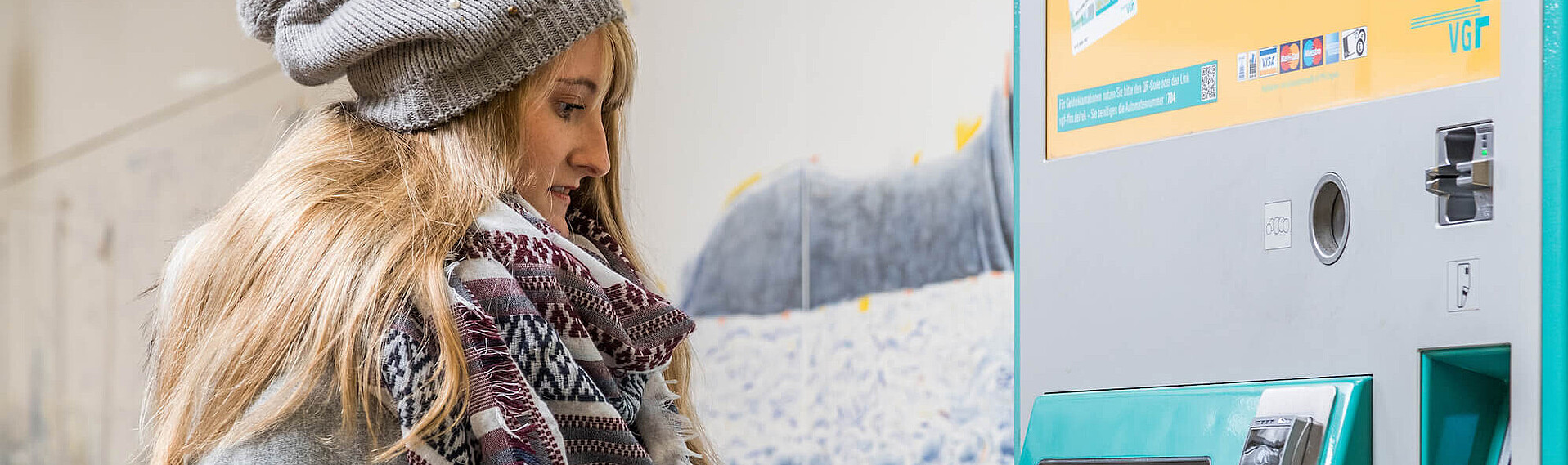 Monatskarten Kauf Header Junge Frau kauft eine Monatskarte am VGF-Fahrkartenautomaten.