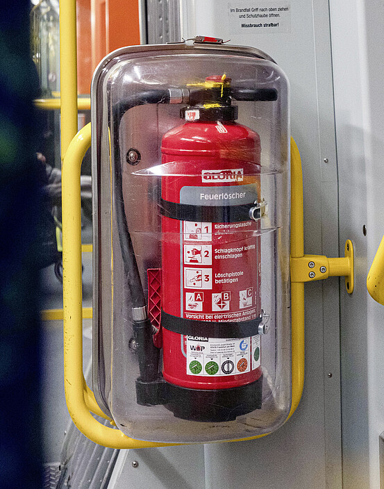 Das Bild zeigt einen Feuerlöscher in einem Fahrzeug.